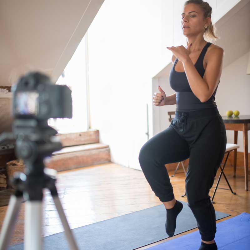 Une femme faisant du sport devant une caméra